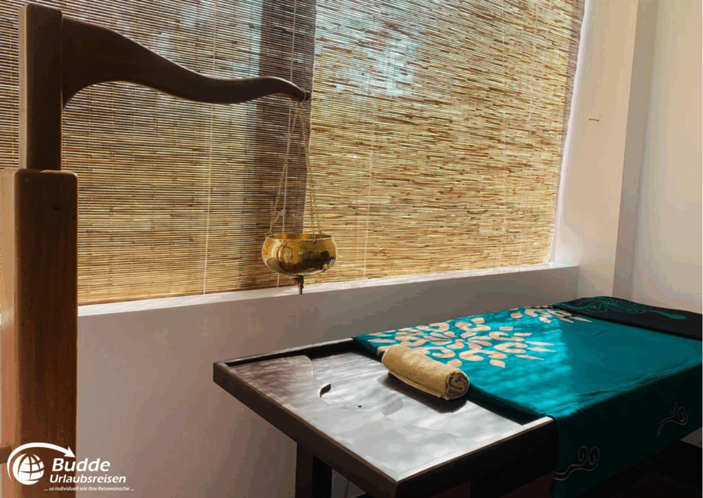 Praana Ayurvedic Boutique Hotel: Ayurveda Behandlungsraum mit einem Massagetisch und einem Ölspender über dem Tisch. - buchbar im Reisebüro Budde Urlaubseisen