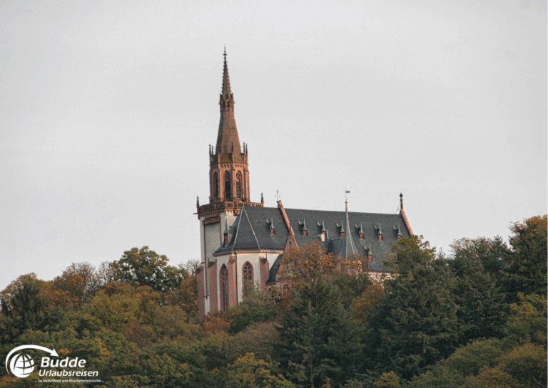 Urlaub an der Nahe: Die Rochuskapelle in Bad Kreuznach mit einem hohen Kirchturm und einem gotischen Dach. - buchbar im Reisebüro Budde Urlaubseisen