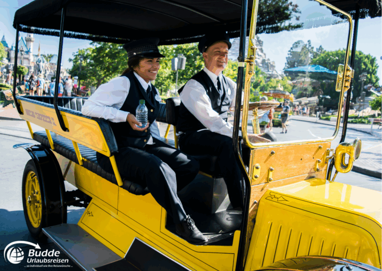 Disneyland Paris: Zwei Fahrer in einem gelben Auto im Disneyland Paris, einer hält eine Wasserflasche.