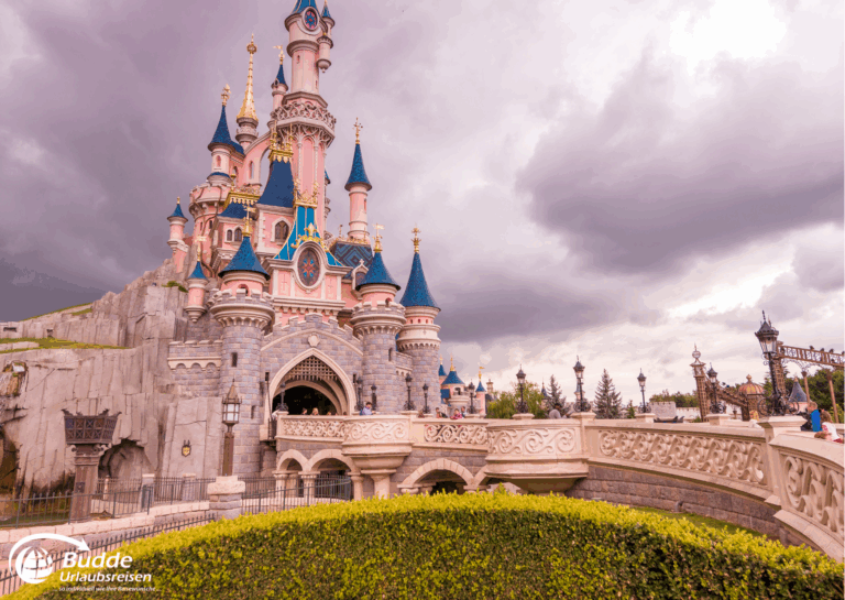 Disneyland Paris: Das Schloss im Disneyland Paris mit bunten Türmen und Wolken im Hintergrund.