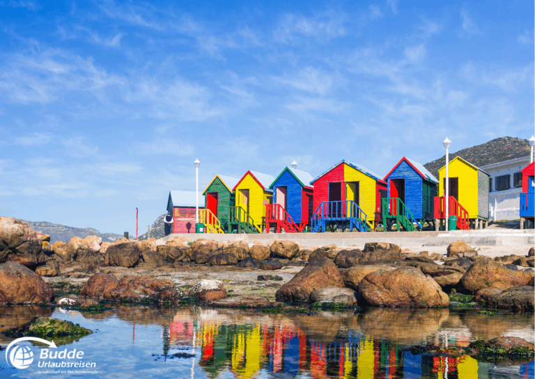 Kreuzfahrt Südafrika Bunte Strandhäuser in verschiedenen Farben an der Küste von Südafrika mit reflektierenden Wasserflächen.
