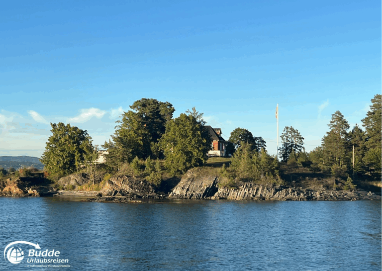 Norwegen Urlaub: Ein rotes Haus auf einer kleinen Insel umgeben von Bäumen und Wasser in Norwegen. Norwegen Urlaub: Ein rotes Haus auf einer kleinen Insel umgeben von Bäumen und Wasser in Norwegen.