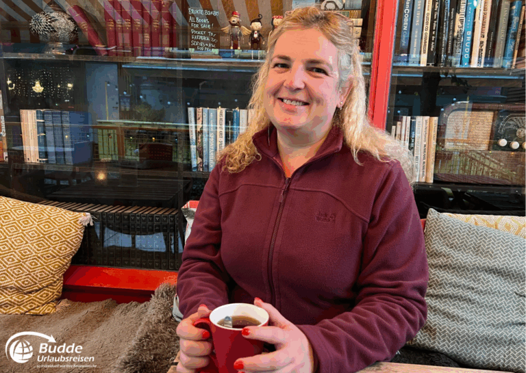 Norwegen Urlaub: Reiseexpertin Anke Budde sitzt in einem Café und hält eine rote Tasse mit Tee. Norwegen Urlaub: Reiseexpertin Anke Budde sitzt in einem Café und hält eine rote Tasse mit Tee.