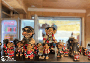 Norwegen Urlaub: Eine Sammlung von verschiedenen Trollfiguren in traditioneller norwegischer Kleidung auf einem Tisch.