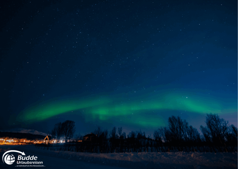 Norwegen Urlaub: Grüne Nordlichter leuchten am Nachthimmel über Tromsø, Norwegen, mit Sternen im Hintergrund. Norwegen Urlaub: Grüne Nordlichter leuchten am Nachthimmel über Tromsø, Norwegen, mit Sternen im Hintergrund.
