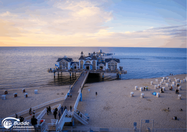 Ostseeurlaub Insel Rügen: Seebrücke in Sellin mit mehreren Gebäuden und einem Holzsteg, der ins Wasser führt.