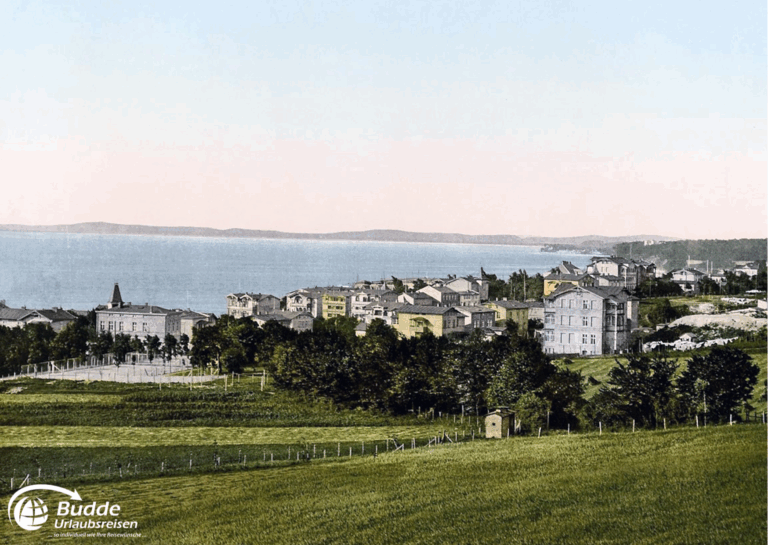 Ostseeurlaub Insel Rügen: Blick auf eine Küstenlandschaft mit mehreren Gebäuden und Wasser im Hintergrund.