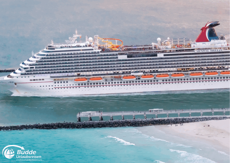 Südamerika Kreuzfahrt: Das Kreuzfahrtschiff Carnival Breeze fährt in ruhigem Wasser mit einer langen Pier im Vordergrund.