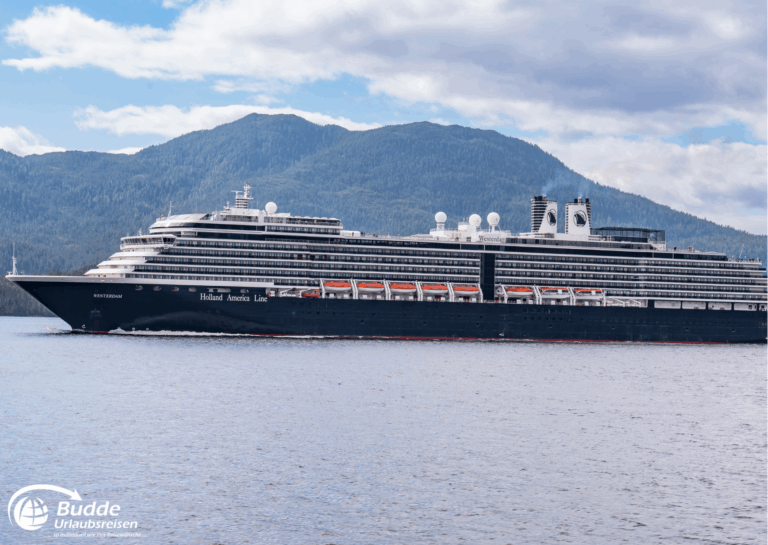 Südamerika Kreuzfahrt: Schwarzes Kreuzfahrtschiff mit mehreren Decks auf ruhigem Wasser vor einer Berglandschaft in Südamerika.