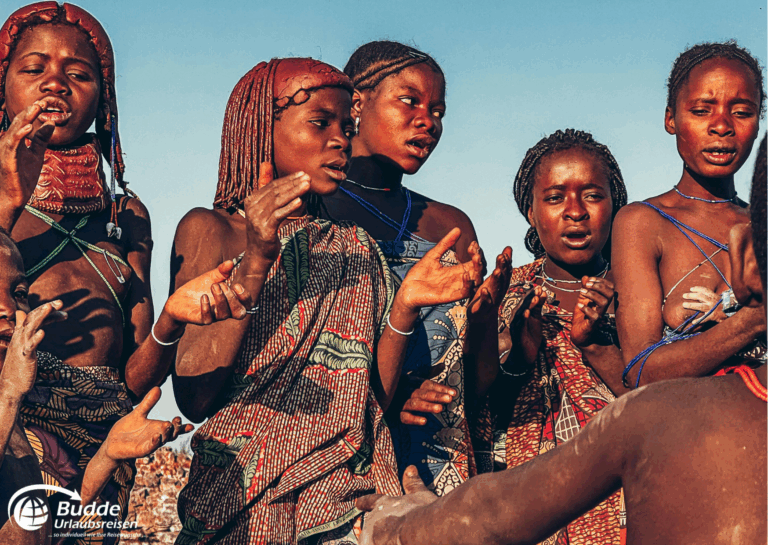 Gruppe von Frauen in traditionellen afrikanischen Trachten, die zusammen singen und tanzen. - Urlaub in Angola buchen