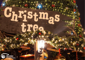 Weihnachtsshopping nach London: Ein Schild mit der Aufschrift 'Christmas tree', umgeben von Lichtern und Weihnachtsdekoration.