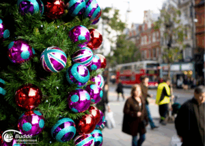 Weihnachtsshopping nach London: Bunte Weihnachtskugeln in Rot, Blau und Lila an einem Weihnachtsbaum in London.