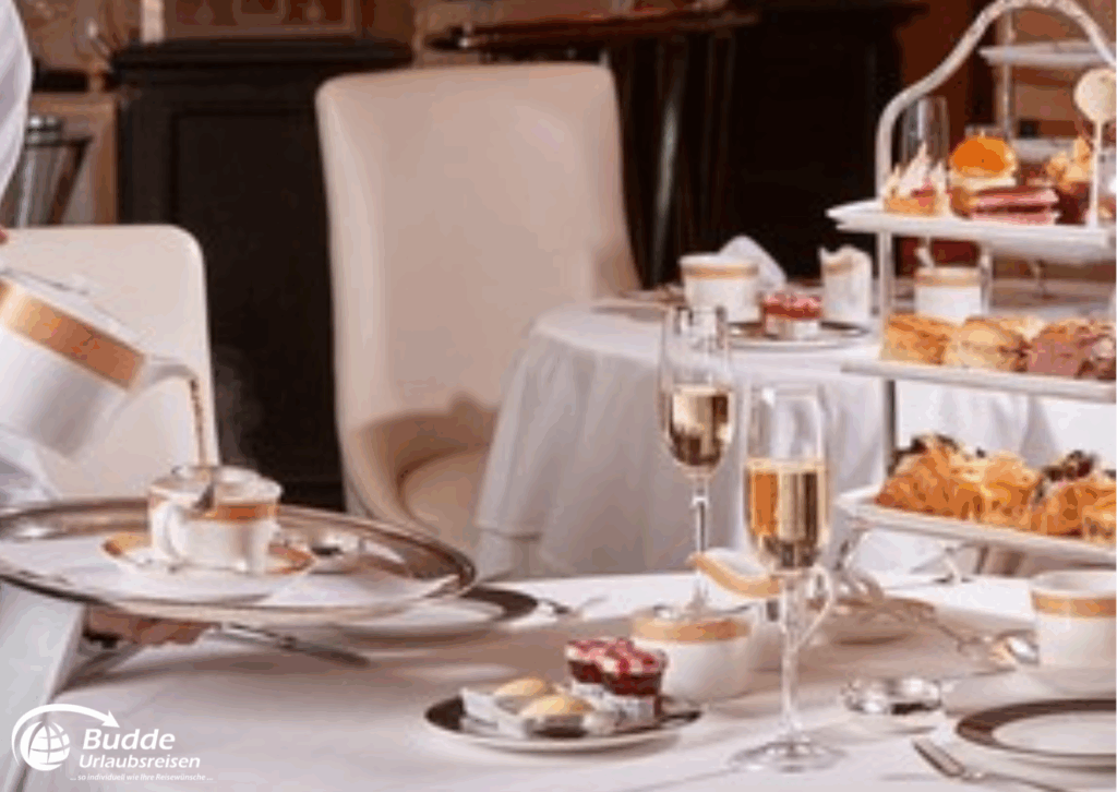 Weltreise Queen Mary 2: Ein gedeckter Tisch mit verschiedenen Desserts und Getränken in eleganter Umgebung.