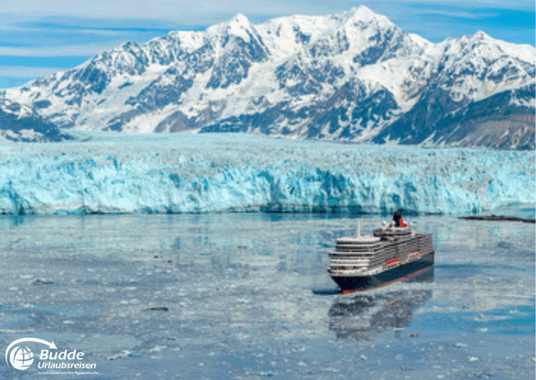 Weltreise Queen Mary 2: Ein Kreuzfahrtschiff fährt durch eisige Gewässer mit einem Gletscher im Hintergrund und Bergen im Hintergrund.
