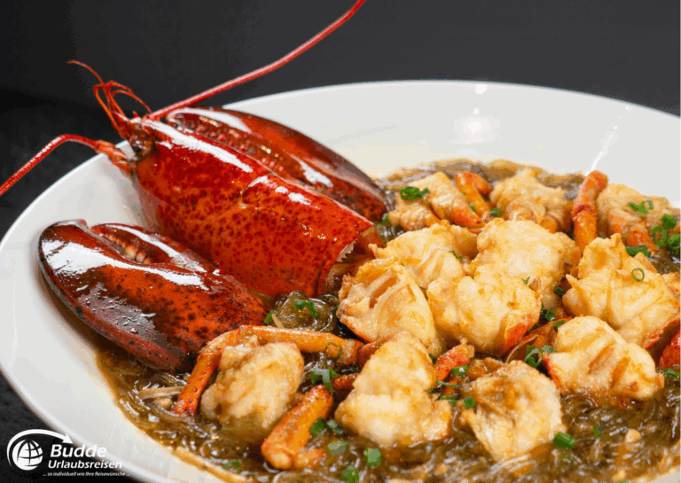 exquisitesten Restaurants: Gekochter Hummer und Garnelen auf einem weißen Teller mit einer dunklen Sauce.