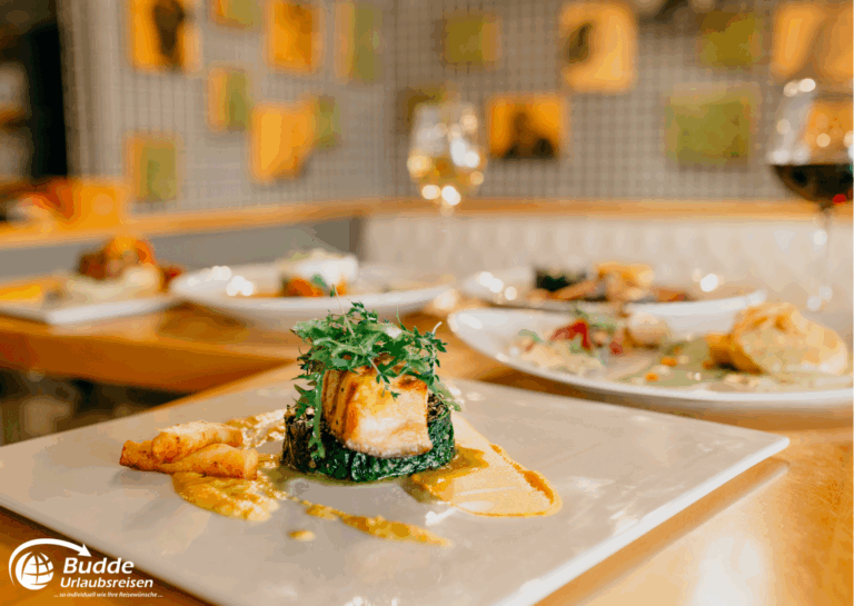 exquisitesten Restaurants: Ein Teller mit Lachs, Gemüse und einer Sauce in einem Restaurant.