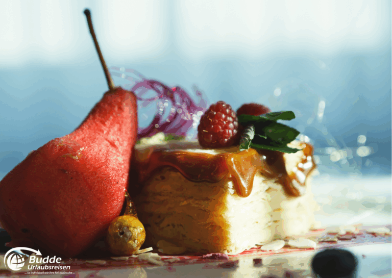 exquisitesten Restaurants: Ein Stück Dessert mit Karamellsoße, einer Birne, Himbeeren und Dekoration aus Zwiebelringen.