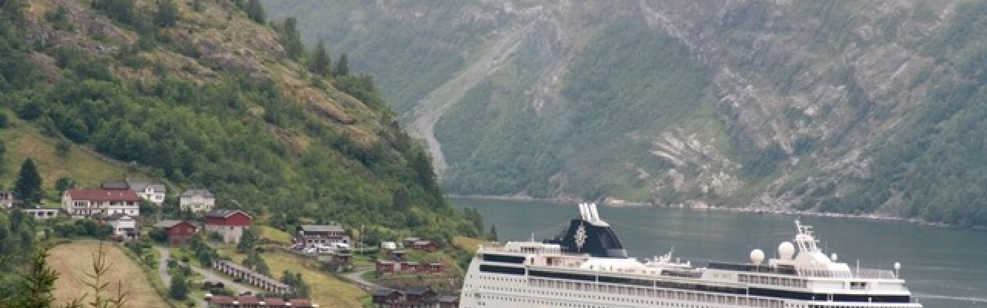 Norwegen-Kreuzfahrt-Geirangerfjord Das atemberaubende Bild zeigt den Geirangerfjord, einen der schönsten Fjorde in Norwegen, während einer unvergesslichen Kreuzfahrt. Das tiefblaue Wasser des Fjords wird von majestätischen Bergen umgeben, die in den Himmel ragen. Die steilen Felswände, üppigen grünen Wiesen und tosenden Wasserfälle verleihen dieser Landschaft eine unwirkliche Schönheit. Die Kreuzfahrt durch den Geirangerfjord ermöglicht es den Reisenden, diese beeindruckende Naturkulisse hautnah zu erleben und die Ruhe und Majestät der norwegischen Fjorde zu spüren. Tauchen Sie ein in diese spektakuläre Umgebung und lassen Sie sich von der beeindruckenden Schönheit des Geirangerfjords verzaubern.