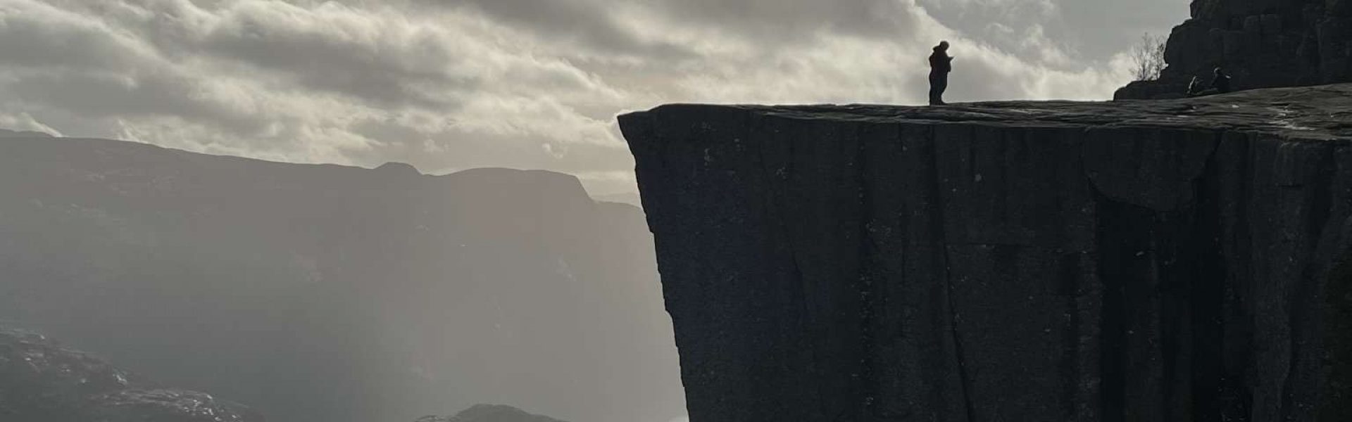 Nebeliger Morgen am Preikestolen Erleben Sie die geheimnisvolle Atmosphäre eines nebeligen Morgens am Preikestolen. Das Bild zeigt den Felsen, der von dichten Wolken umhüllt ist, während Wanderer ihren Weg durch den Nebel finden. Diese mystische Szene verleiht der Wanderung eine besondere Stimmung und lädt dazu ein, die unerwarteten Facetten der Natur zu entdecken.