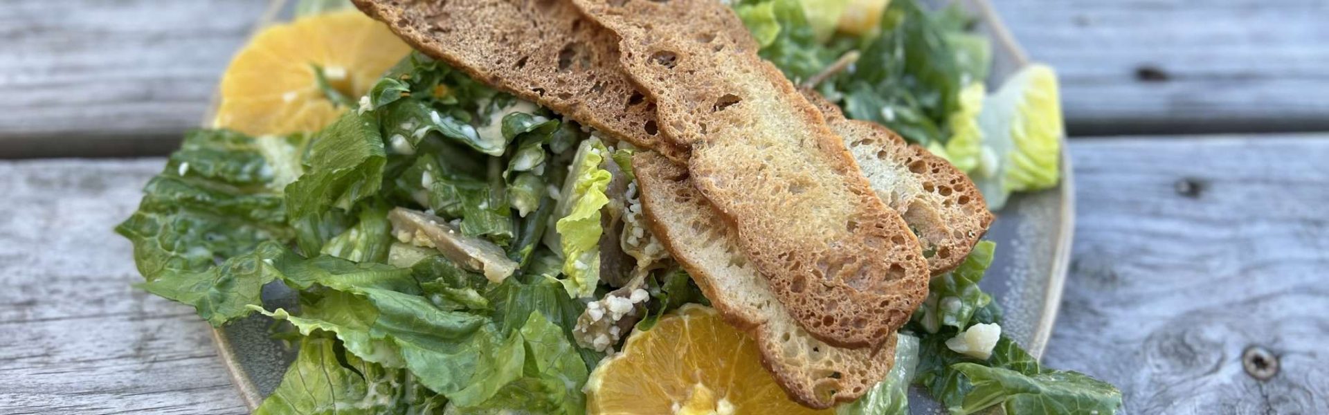 Frischer Salat mit Croutons und Orangenscheiben