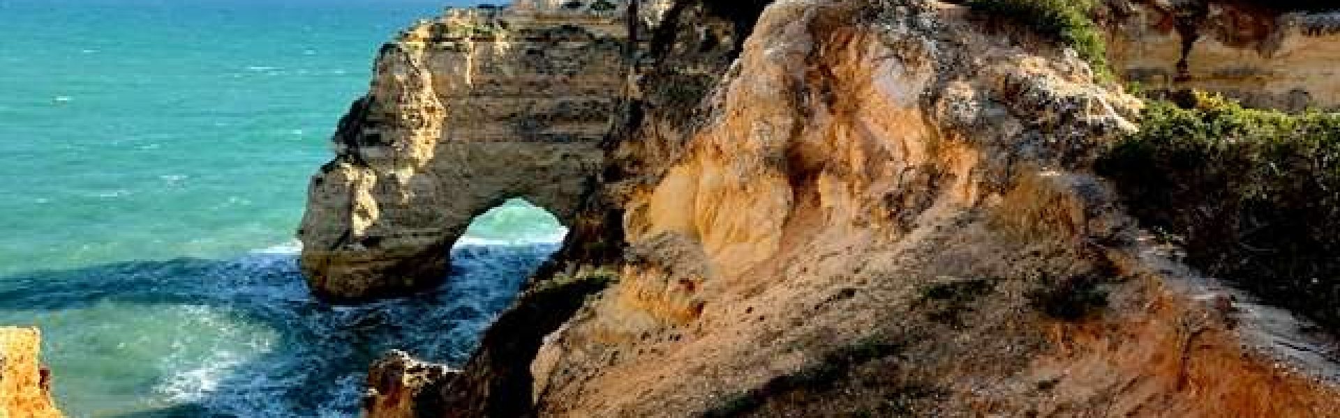 Felsformation mit natürlichem Bogen an der Algarve-Küste.